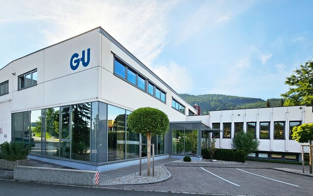 Modernes Bürogebäude mit großen Fenstern und GU Logo || Österreich