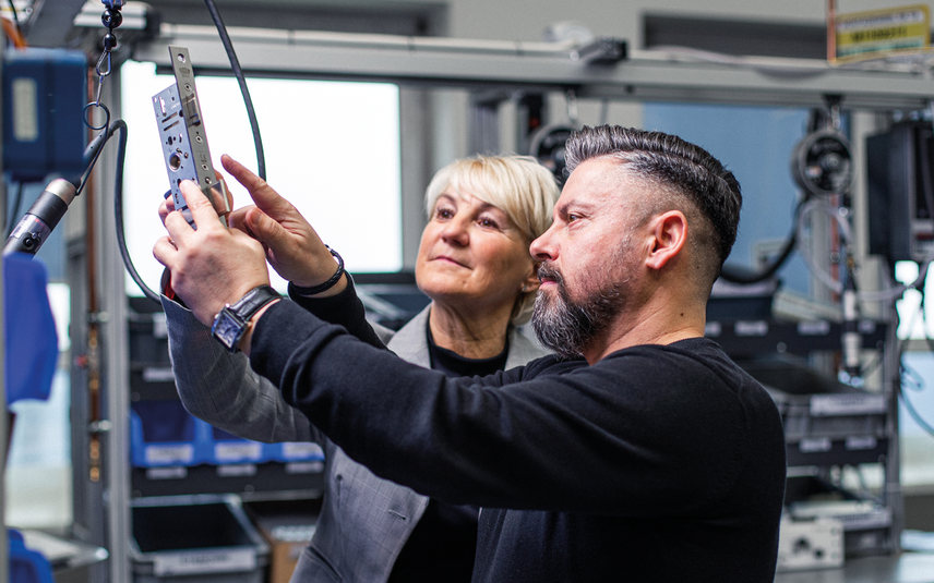 Fachkräfte prüfen Metallbauteil gemeinsam
