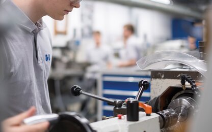 Junger Mitarbeiter bei der Arbeit in der Produktion von Werkzeugen und Beschlägen, mit Fokus auf Präzision, Fertigungstechnologie und handwerkliches Geschick.