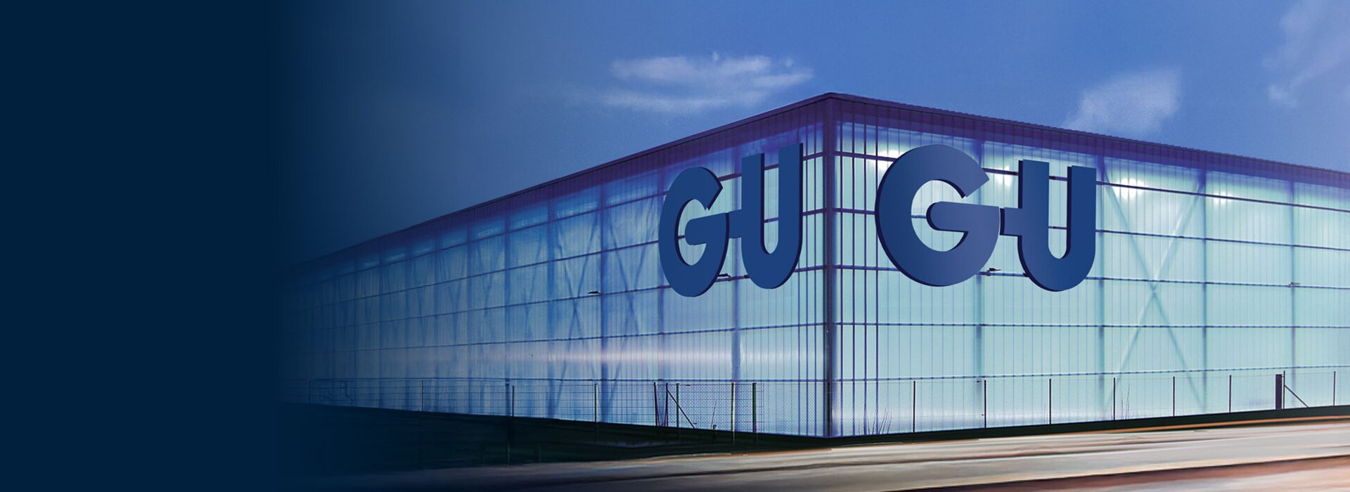 Leuchtendes Gebäude mit GU Schriftzug