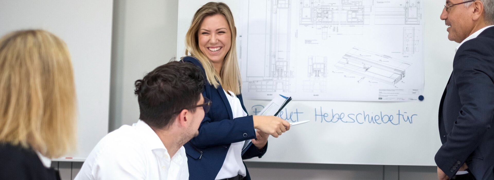 Žena ukazuje technický výkres křídla zdvižně-posuvných dveří