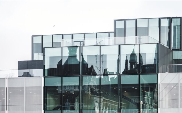 стеклянный фасад с отражением исторической архитектуры