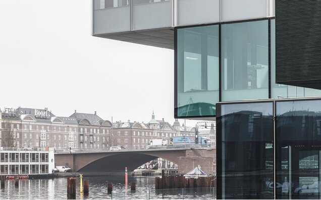 стеклянный фасад с мостом и старым зданием