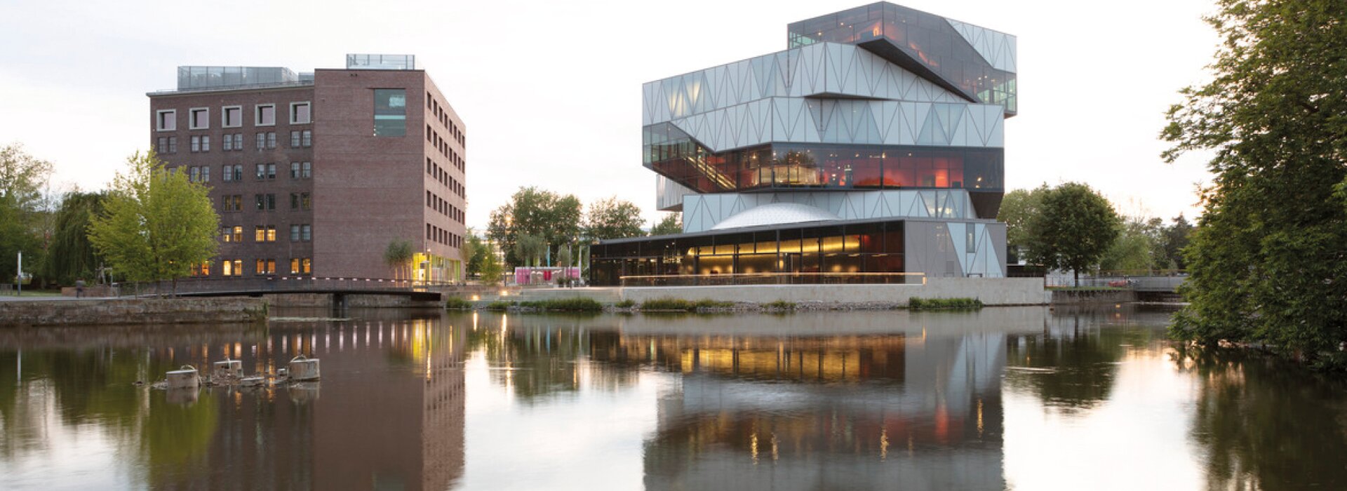 здание с отражением в воде и освещением