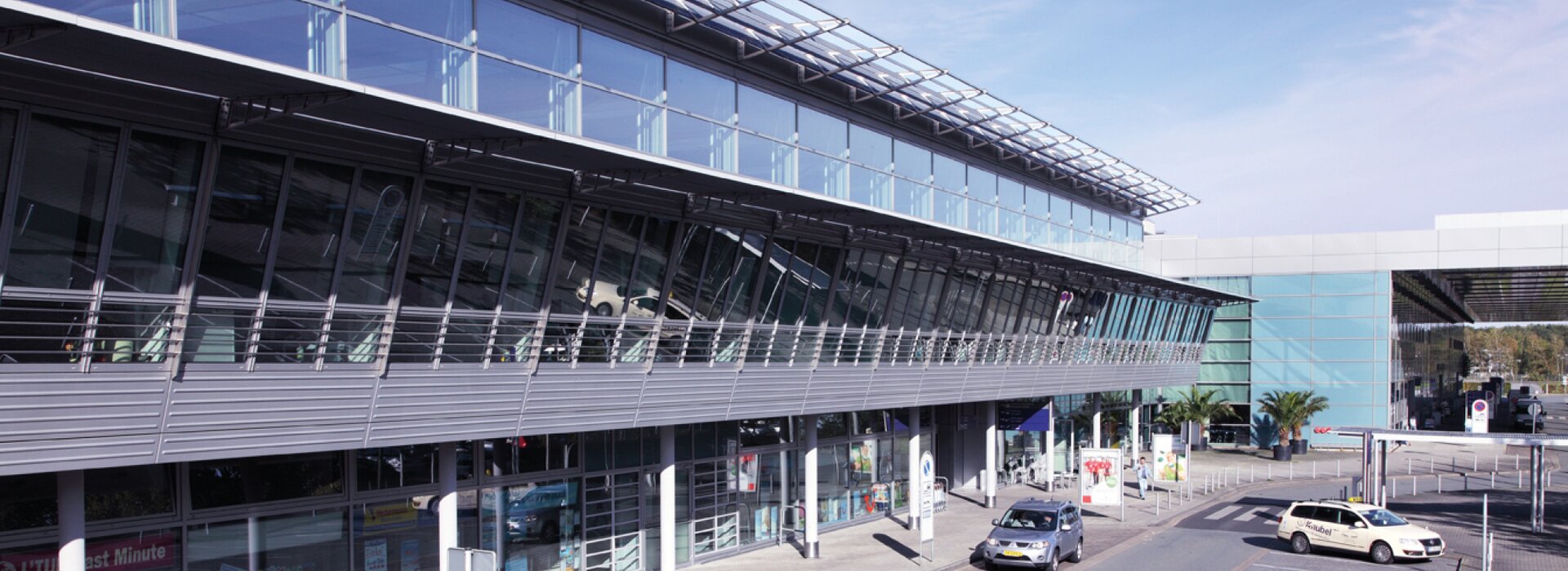 otopark alanları ve arabalar ile havalimanı terminali