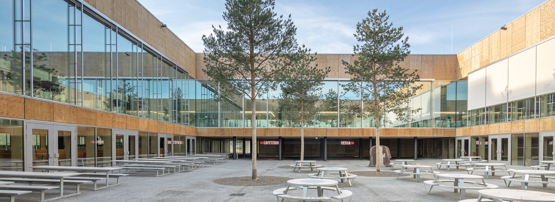 Oturma alanları ve ağaçlar bulunan avlu