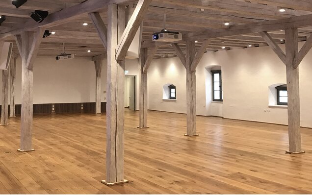 Large room with wooden beams and floor