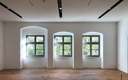 Bright room with three windows and wooden floor