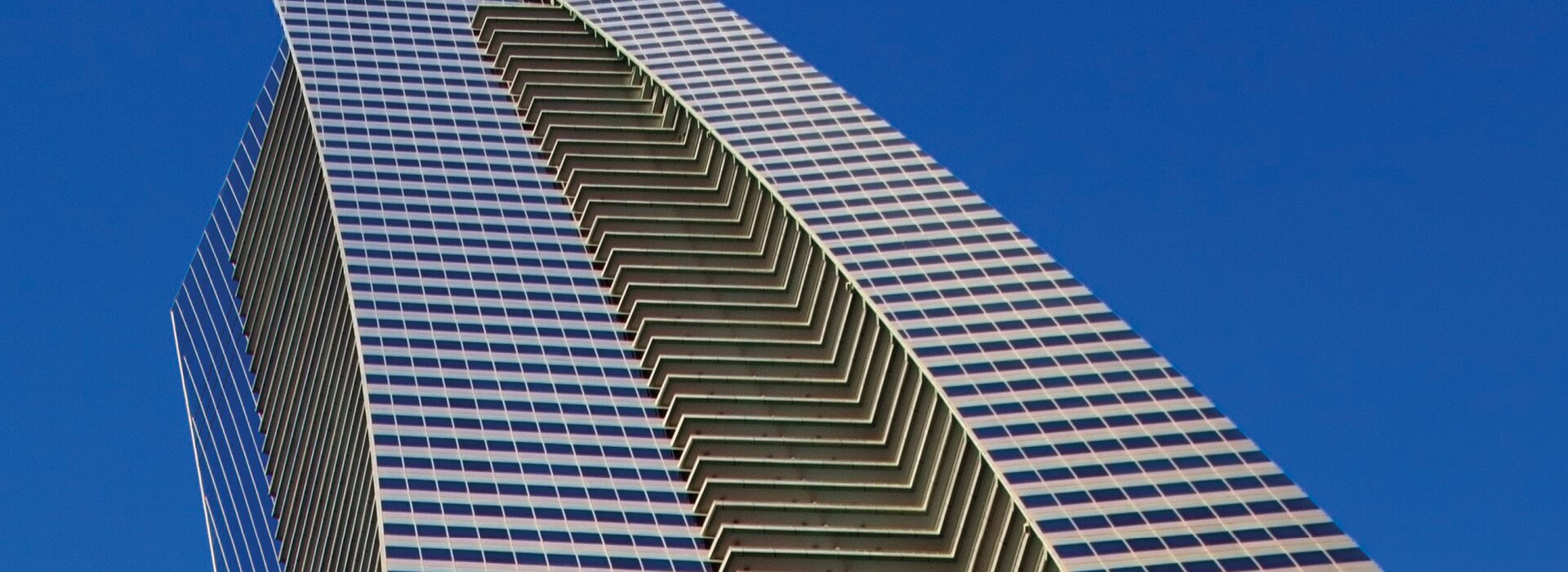 High-rise building with glass facade and blue sky