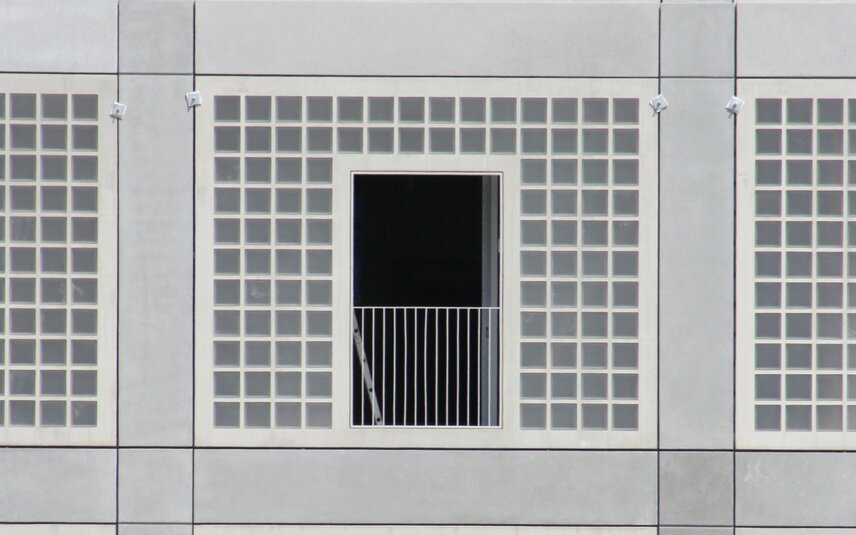 Grey façade front with balcony and grid