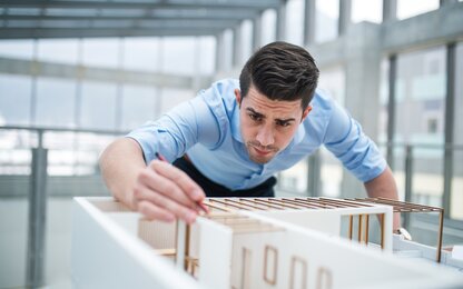 Architekt bei der Gestaltung eines Gebäudemodells im modernen Büro